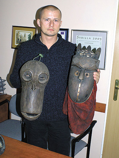 Marek Dzierżęga prezentuje maski, które podarował muzealnikom