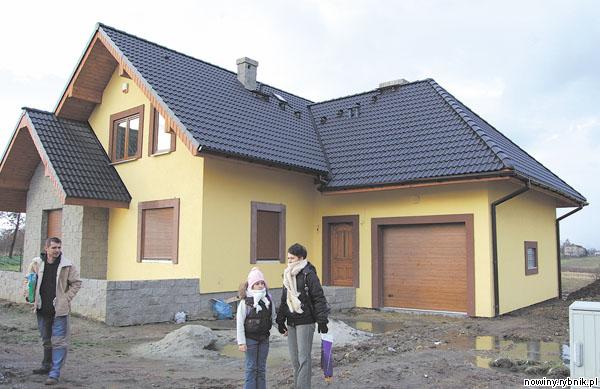 Urszula i Piotr Macionczykowie z córeczką przed swoim pechowym domem