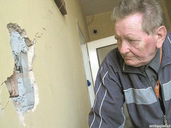 Bogusław Grabiński z niepokojem przygląda się ścianie swojego mieszkania