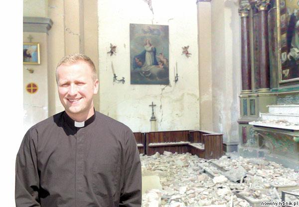 Odbudowa mojego kościoła potrwa lata – mówi ksiądz Marcin Gajda. W tle: ruiny świątyni