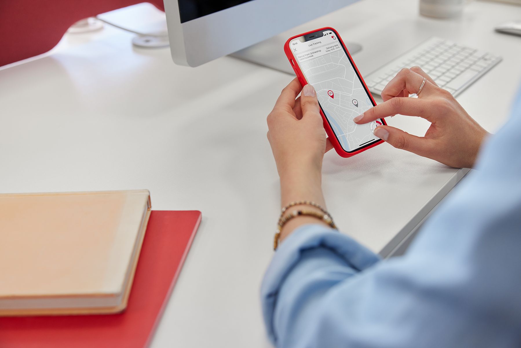 Pracownica zarządza paczką za pomocą aplikacji mobilnej DPD Polska przy swoim biurku